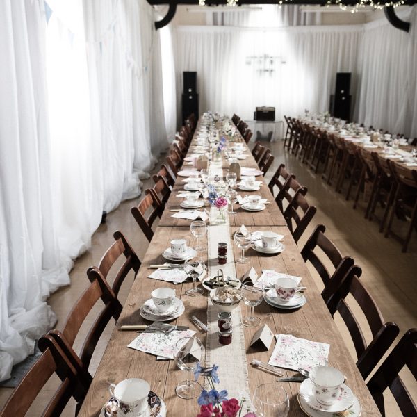 Rustic tables and wooden folding chairs at a wedding - BE Event Hire