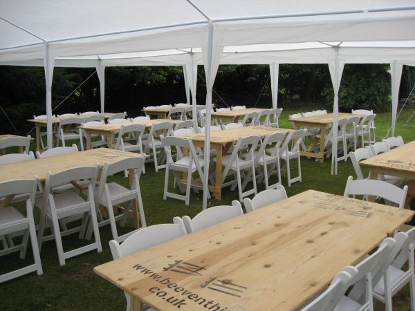 White folding chairs 2 White folding chair and wooden trestle tables hired for outdoor wedding - BE Event Hire